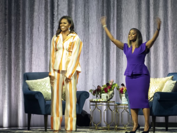 Isha Sesay waves her arms as crowd greets Michelle Obama